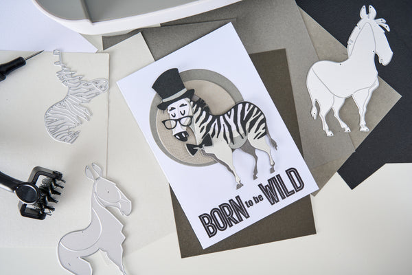 Card with zebra illustration and 'Born to be Wild' text, surrounded by paper cutouts of animals.