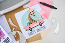 Card with a giraffe in a pink car and 'Party Animal' text on a crafting surface.