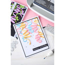 Colorful 'happy birthday' card with cutting dies on a pink surface
