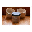 Jar of Speedball Mid-Fire Glaze Champagne Quartz with ceramic bowls on a wooden surface