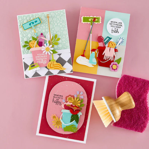 Three colorful greeting cards with cleaning-themed illustrations on a pink background, accompanied by cleaning tools.