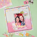 Scrapbook page with a photo of two people and decorative elements on a green background