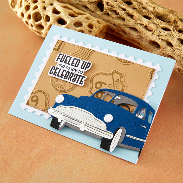 Card with a blue car design and text 'Fueled up and ready to celebrate' on a textured surface.