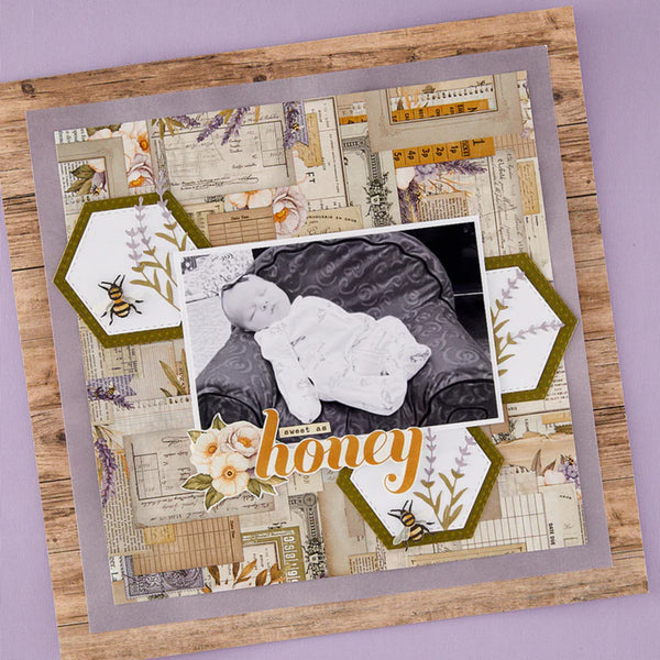 Scrapbook page with baby photo and decorative elements on a wooden surface