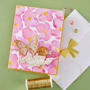 Greeting card with pink floral design and butterfly, accompanied by a white envelope and gold thread on a green background.