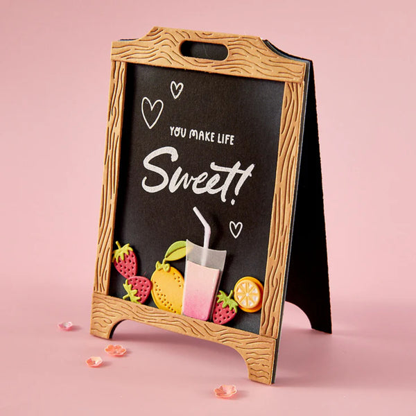 Chalkboard sign with decorative elements and 'You make life sweet!' text on a pink background