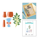 Set of craft supplies including cut-out shapes of vases, a plant, and a bow, with a card and paper in the background.