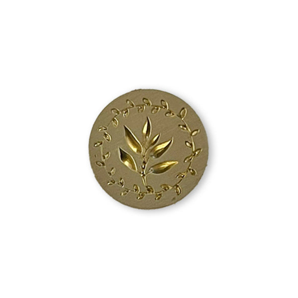 Gold circular emblem with leaf design on a white background
