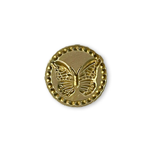 Gold button with butterfly design on a white background