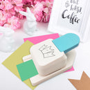 White stamp with blue handle on a white surface with pink flowers and a rabbit figurine in the background.