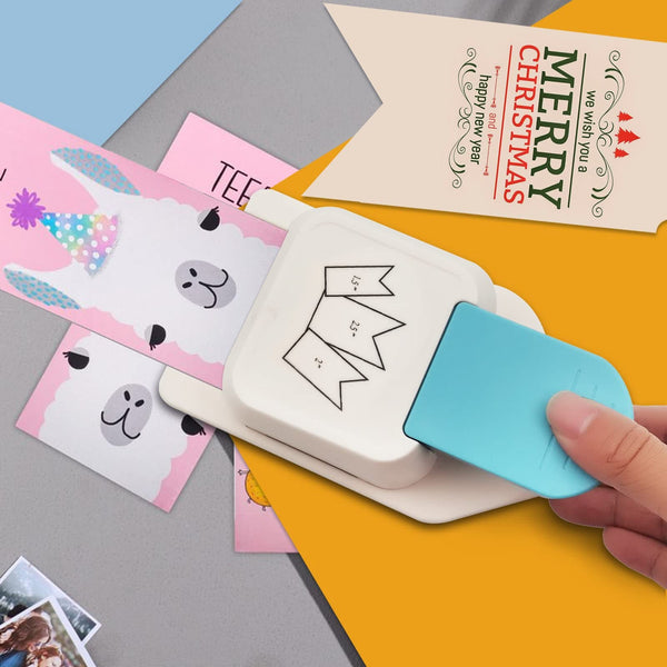 Hand using a white card puncher on colorful cards with a 'Merry Christmas' card in the background.