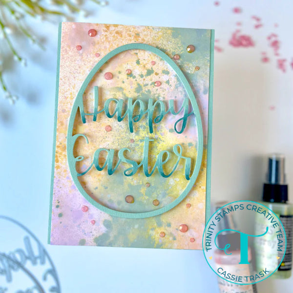 Easter card with 'Happy Easter' text on a watercolor background, featuring Trinity Stamps logo.