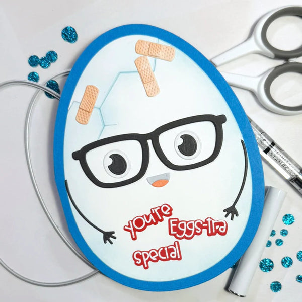 Cartoon egg with glasses and band-aids on a white background with crafting supplies.