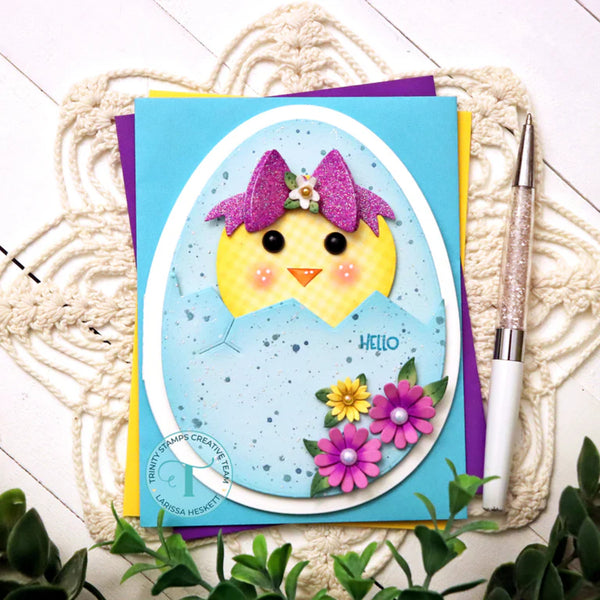 Card with a chick design and flowers on a textured surface