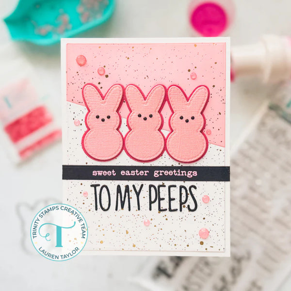 Card with pink bunny illustrations and text 'sweet easter greetings TO MY PEEPS' on a blurred background.