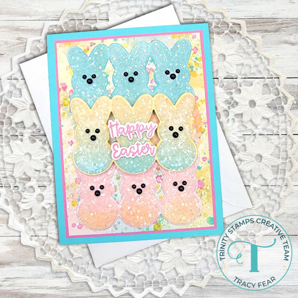 Card with pastel-colored bunny faces and 'Happy Easter' text on a textured surface.