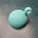 Turquoise ball with a handle on a textured gray surface