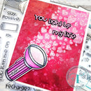 Card with pink flashlight illustration and 'You light up my life' text, surrounded by craft supplies.