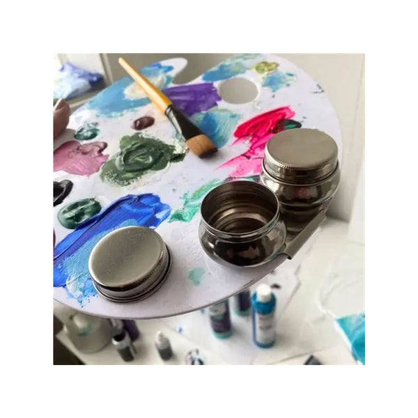 Artistic setup with a paint palette, brushes, and containers on a white background