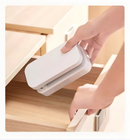 Hand picking up the white folded Universal Crafts Artlight pro out of a   wooden cabinet draw.