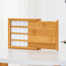 Wooden tea box with a sliding lid on a white surface