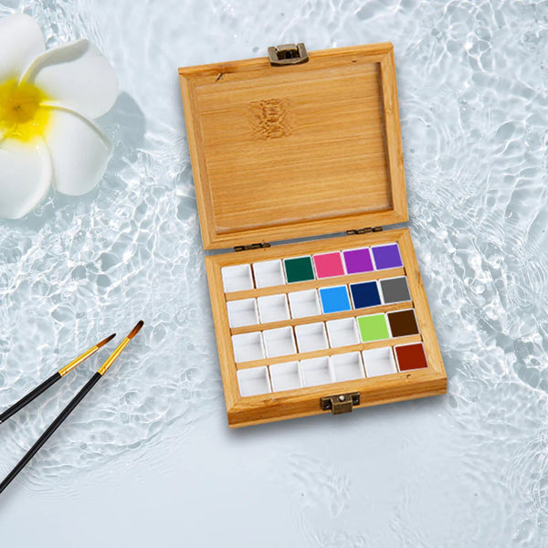 Wooden watercolor paint set with brushes on a light background