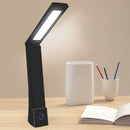 Black LED desk lamp on a wooden surface with a book and pen holder in the background.
