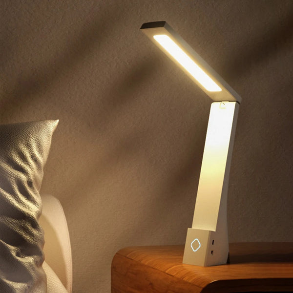 Foldable LED desk lamp on a wooden surface with a soft background