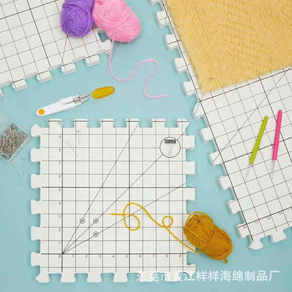 Grid-patterned foam mats with yarn and tools on a light blue background