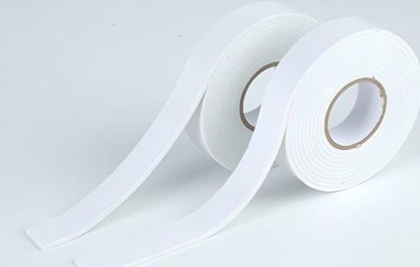 Roll of white tape on a light gray background