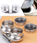 Set of silver metal containers with lids on a wooden surface.