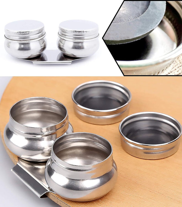 Set of silver metal containers with lids on a wooden surface.