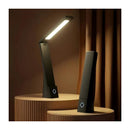 Black desk lamp on a wooden platform with a warm brown background