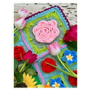 Colorful crocheted flower pattern with tulips and roses on a wooden surface