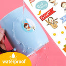 Hand holding a waterproof card with cartoon character, surrounded by colorful stickers on a pink background.
