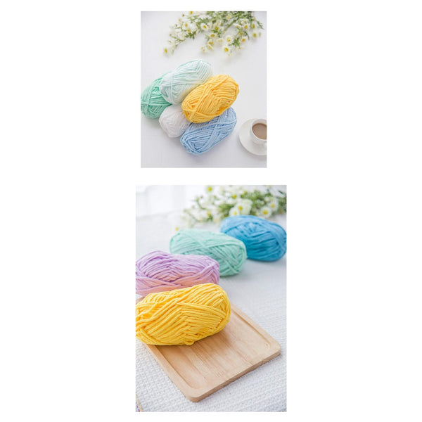 Colorful yarn balls on a white surface with flowers and a cup.