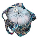 Drawstring bag with floral pattern containing a light blue ball on a white background