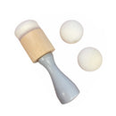 White wooden rattle with beige top and three white balls on a white background
